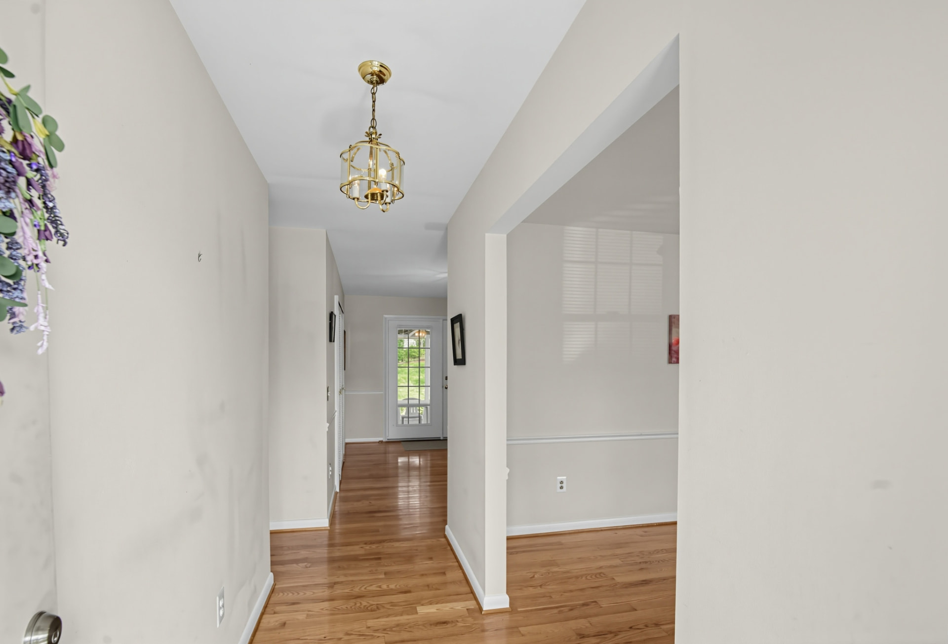 Entry hallway with hardwood floors and a brass lantern light