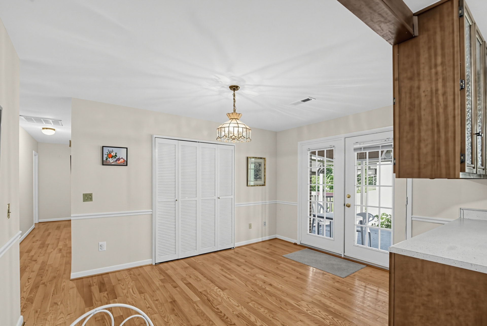 Dining room with hardwood floors, chandelier and doors to the porch